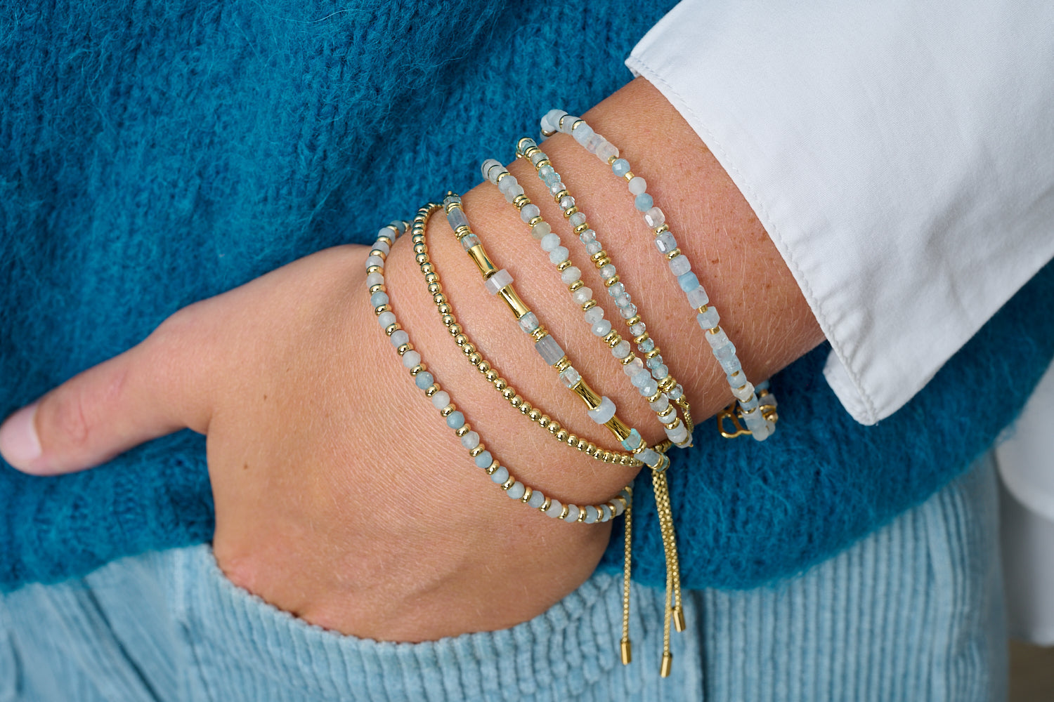 Chiara Gold & Blue Topaz Bead Slider Bracelet styled with soft blue gemstones and golden accents in a boho-luxe layered bracelet stack.