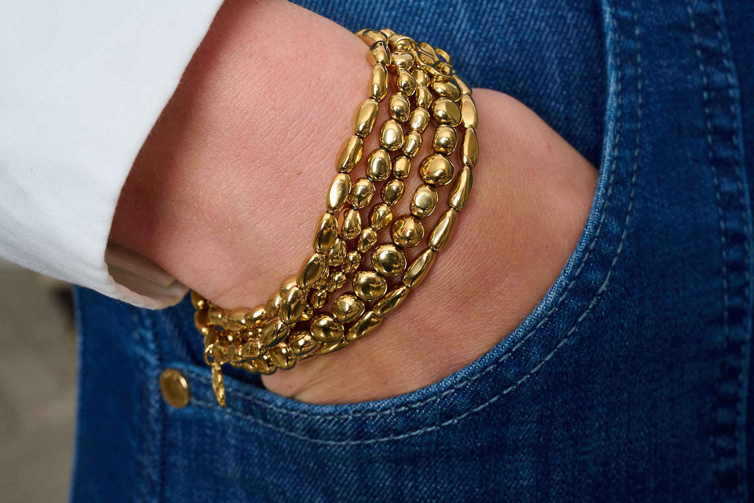 Flavia Gold Stretch Bead Bracelet featured on wrist with Boho Betty stacking bracelets in gold and gemstone tones.