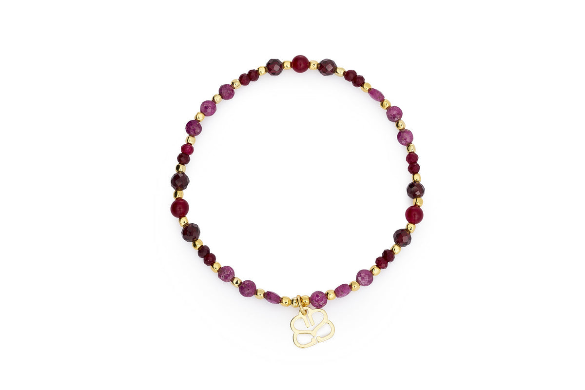 Laria gold stretch bracelet with garnet January birthstone beads and Boho Betty charm on white background