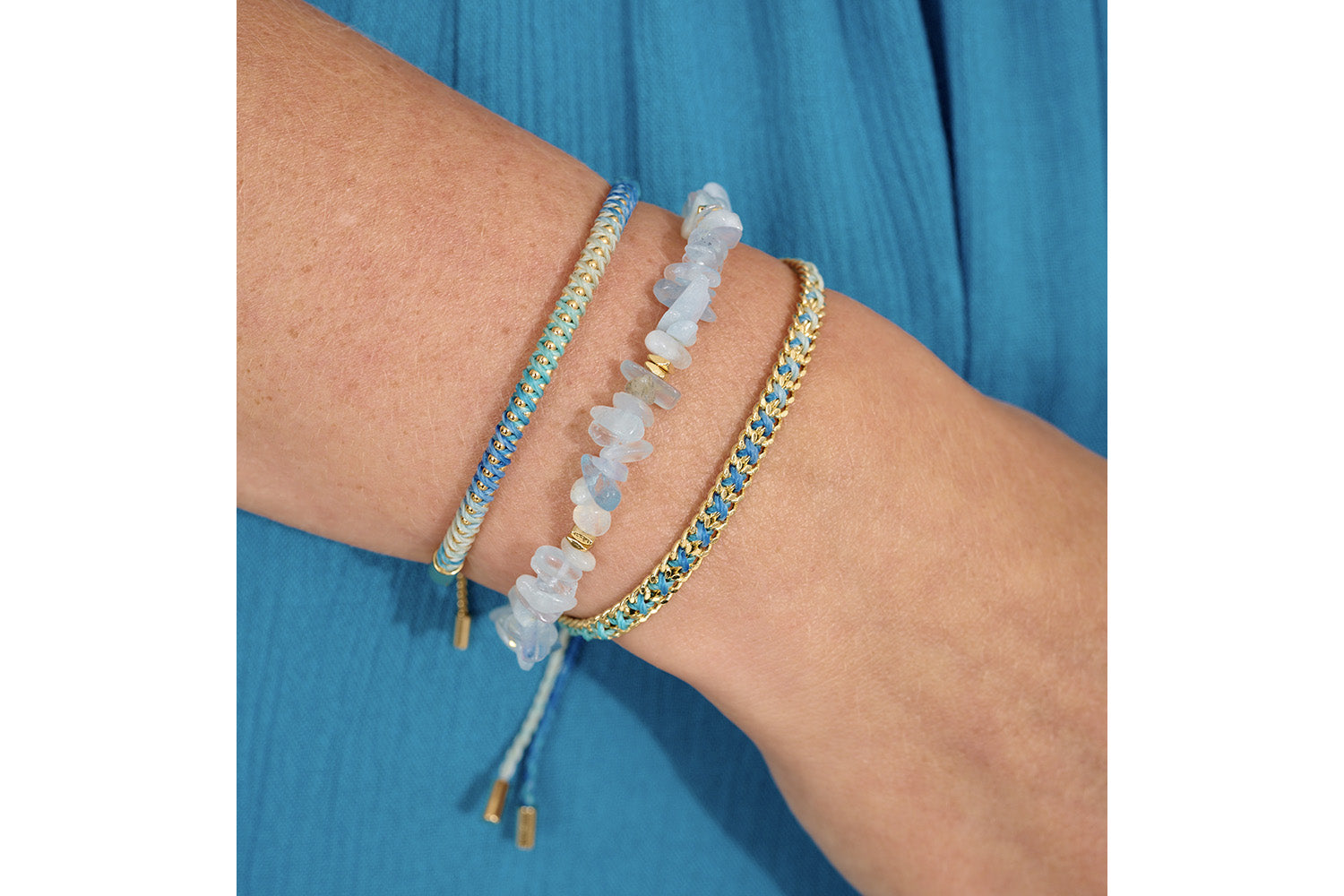 Lilia Gold & Blue Ombre Braided Bracelet styled on wrist, showcasing ombre ocean blues, shimmering gold chain, and a boho summer jewellery vibe.