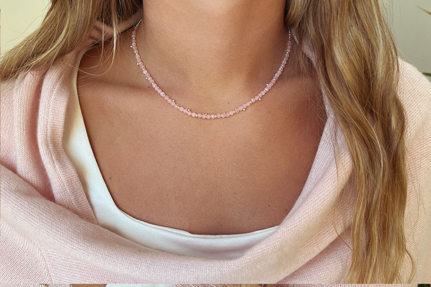 Salus Rose Quartz Gold Necklace styled around the neckline, showcasing natural rose quartz gemstones and waterproof gold PVD details designed for everyday wear and effortless layering.