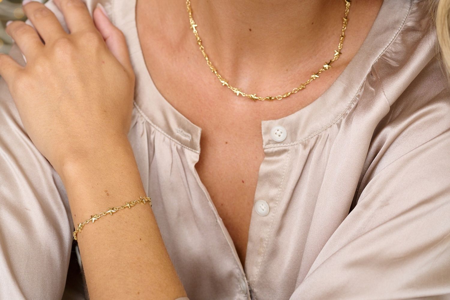 Lifestyle image showcasing the Mensa gold star bracelet and matching Delos Gold star necklace