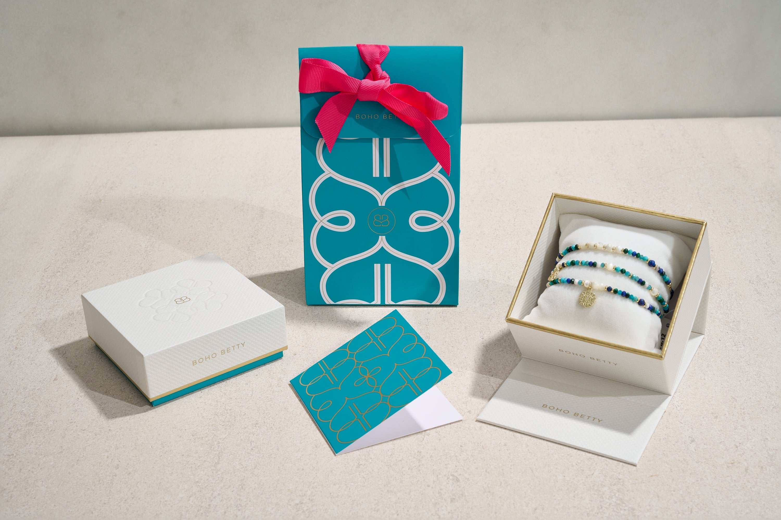 Boho Betty turquoise gift packaging, luxury jewelry box with gold accents, and beaded bracelets displayed for gifting.