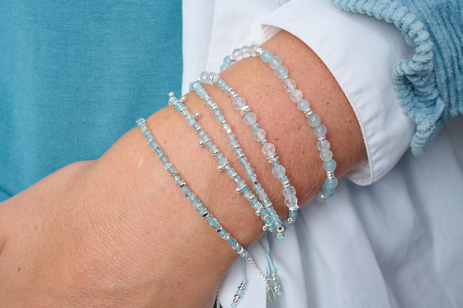Laria Blue Topaz & Silver Beaded Bracelet featured on wrist with Boho Betty stacking bracelets in silver and blue gemstone tones.