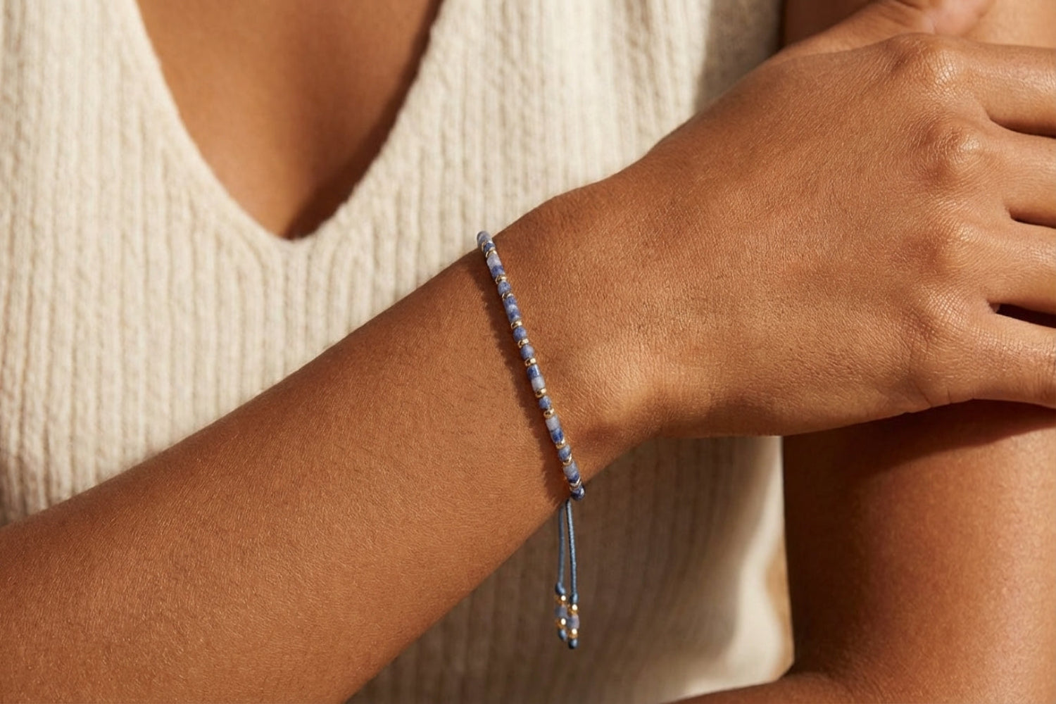 Bracelet rested on a polished marble surface, showcasing intricate design with blue aventurine and gold accents from a top-down view.