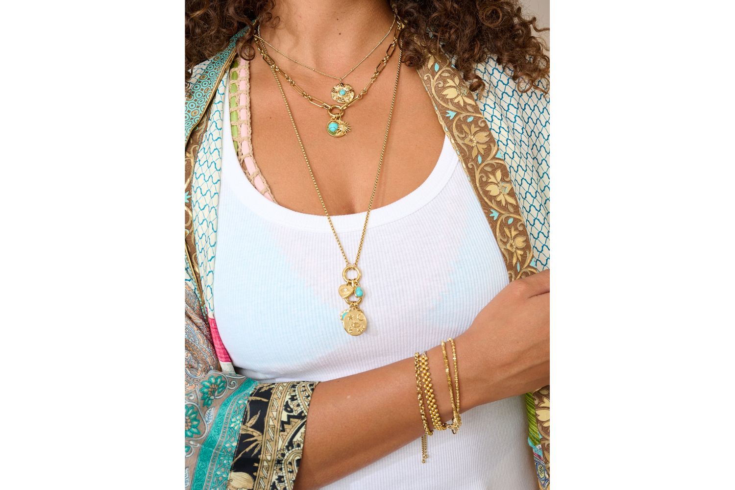 Model wearing Savina gold hoops and Hemani turquoise charm necklace layered for a golden boho look.