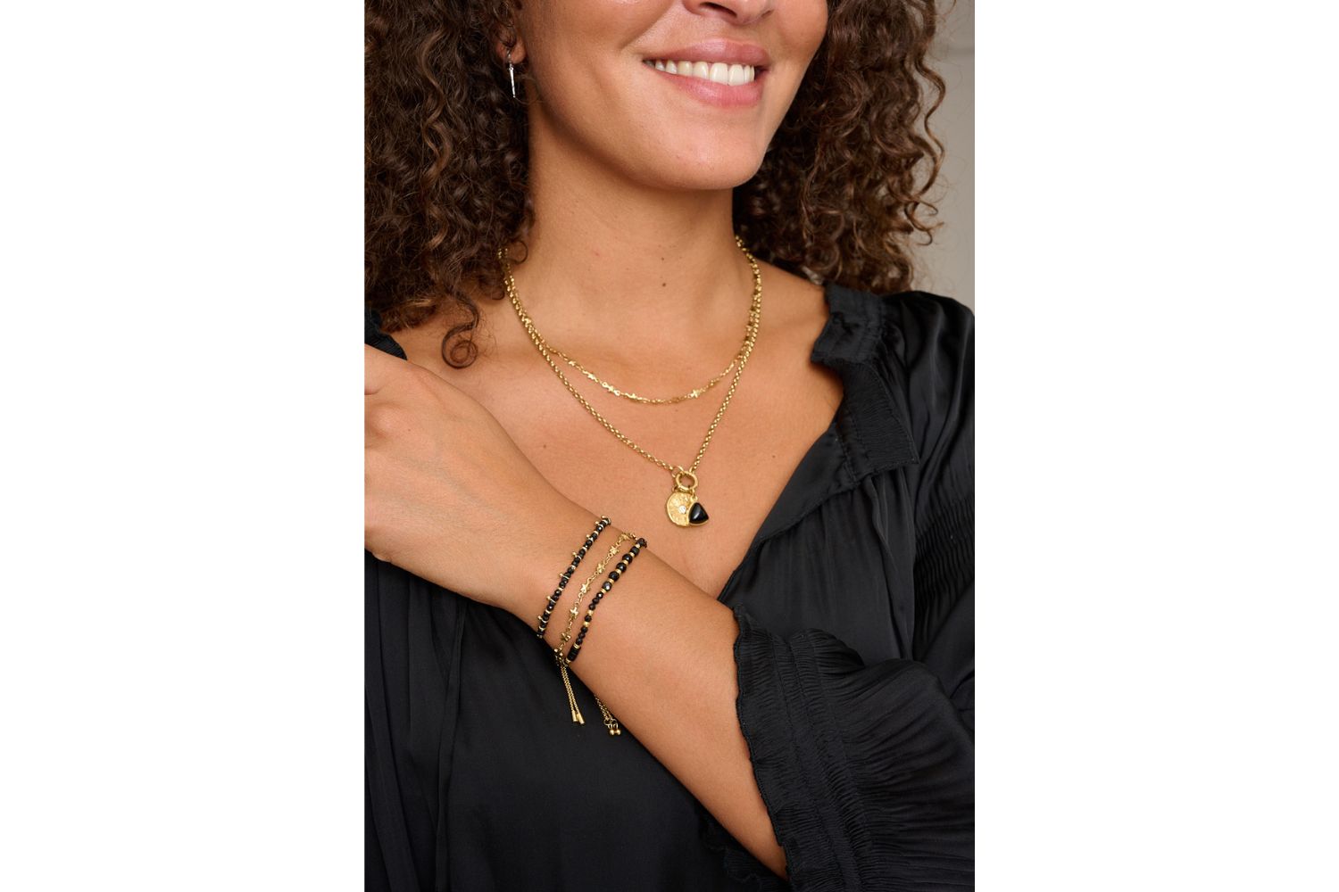 Solara Gold Star Chain Necklace styled with layered boho jewelry and celestial accents in warm golden light.